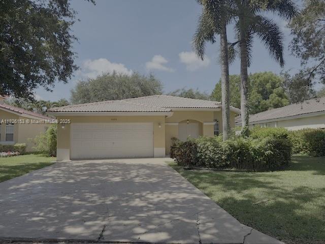 4390 NW 41st Pl, Coconut Creek, FL 33073 - mediterranean / spanish home featuring a garage, a tile roof, concrete driveway, stucco siding, and a front lawn