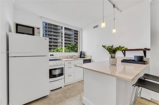 2951 S Bayshore Dr Unit 717, Miami, FL 33133 - kitchen with white appliances, white cabinetry, light countertops, decorative light fixtures, and a peninsula