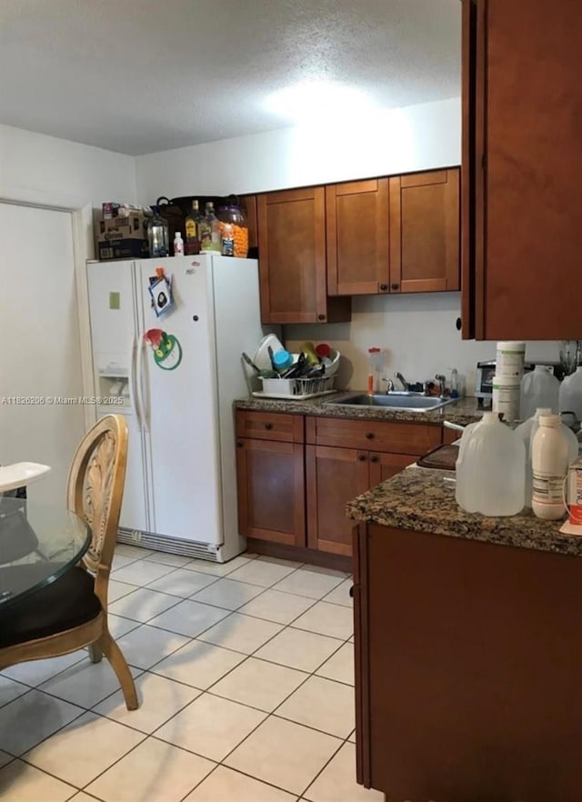 7023 SW 19th St, North Lauderdale, FL 33068 - kitchen featuring white fridge with ice dispenser, brown cabinets, and light tile patterned flooring