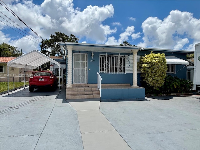 1041 NW 33rd Ave, Miami, FL 33125 - view of front of property featuring a detached carport, a porch, and driveway