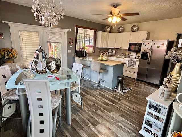 1041 NW 33rd Ave, Miami, FL 33125 - kitchen featuring white electric range oven, stainless steel fridge, black microwave, a peninsula, and dark wood finished floors