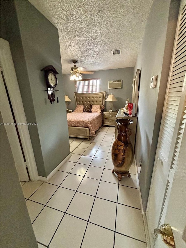 1041 NW 33rd Ave, Miami, FL 33125 - bedroom with light tile patterned flooring, a textured ceiling, a wall mounted air conditioner, and ceiling fan