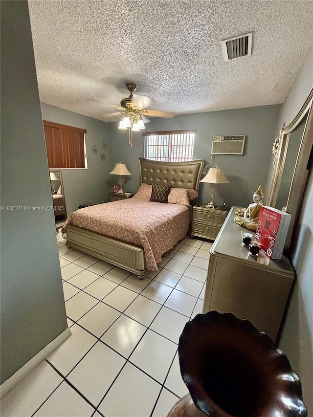1041 NW 33rd Ave, Miami, FL 33125 - bedroom with light tile patterned floors, a textured ceiling, ceiling fan, and an AC wall unit