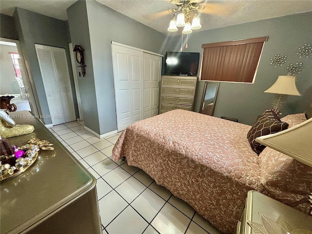 1041 NW 33rd Ave, Miami, FL 33125 - bedroom with light tile patterned floors, a textured ceiling, and multiple closets