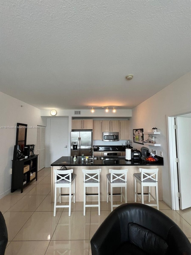 79 SW 12th St Unit 1603-S, Miami, FL 33130 - kitchen with appliances with stainless steel finishes, a breakfast bar, light tile patterned flooring, a peninsula, and a textured ceiling