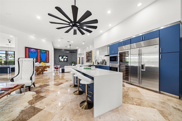 17490 SW 70th Pl, Southwest Ranches, FL 33331 - kitchen featuring blue cabinets, built in appliances, ceiling fan, a kitchen bar, and light countertops
