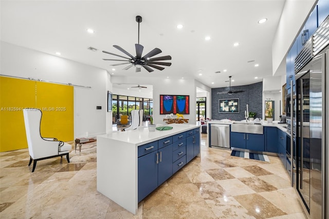 17490 SW 70th Pl, Southwest Ranches, FL 33331 - kitchen with blue cabinets, a ceiling fan, open floor plan, recessed lighting, and stainless steel appliances