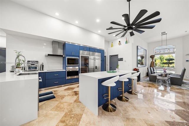 17490 SW 70th Pl, Southwest Ranches, FL 33331 - kitchen featuring built in appliances, wall chimney exhaust hood, blue cabinetry, light countertops, and recessed lighting