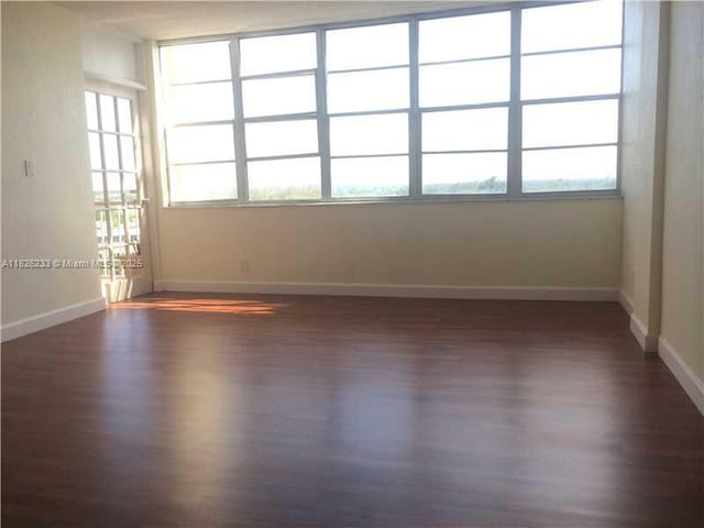 2025 NE 164th St Unit 901, North Miami Beach, FL 33162 - spare room featuring dark wood-style floors and baseboards