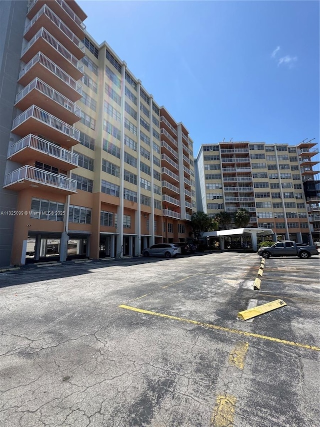 2025 NE 164th St Unit 206, North Miami Beach, FL 33162 - view of apartment building / complex featuring uncovered parking
