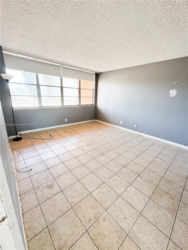 2025 NE 164th St Unit 206, North Miami Beach, FL 33162 - unfurnished room with a textured ceiling and light tile patterned floors