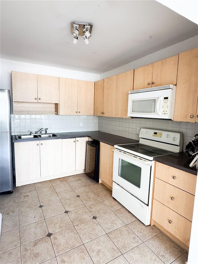 2025 NE 164th St Unit 206, North Miami Beach, FL 33162 - kitchen with white appliances, light brown cabinetry, backsplash, and dark countertops
