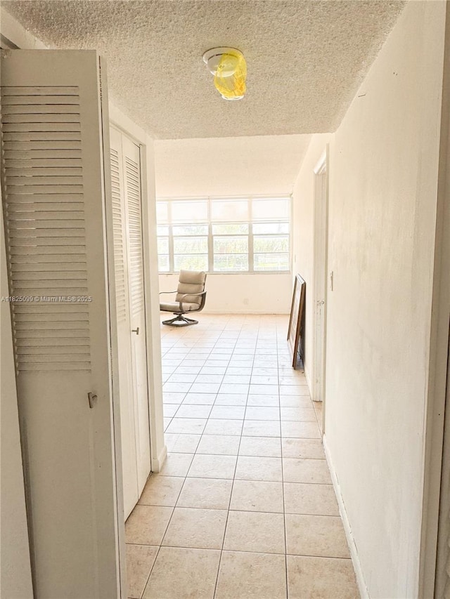 2025 NE 164th St Unit 206, North Miami Beach, FL 33162 - hall with light tile patterned flooring and a textured ceiling