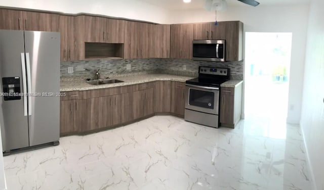 6710 SW 18th Ct, North Lauderdale, FL 33068 - kitchen with stainless steel appliances, tasteful backsplash, a ceiling fan, light stone counters, and brown cabinetry