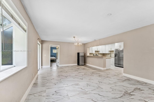 919 NE 4th St, Hallandale Beach, FL 33009 - kitchen featuring stainless steel fridge with ice dispenser, freestanding refrigerator, a chandelier, white cabinets, and open floor plan