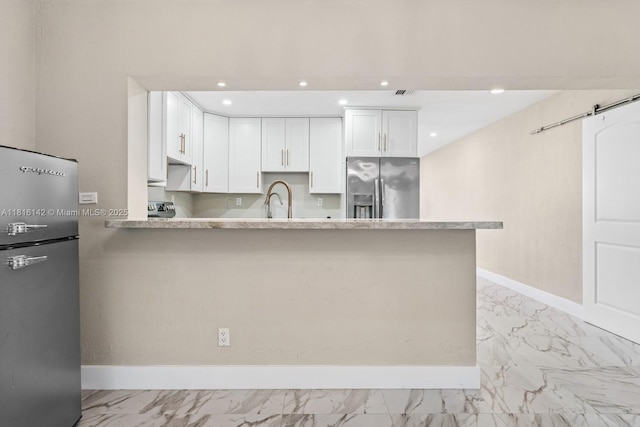 919 NE 4th St, Hallandale Beach, FL 33009 - kitchen featuring stainless steel fridge with ice dispenser, freestanding refrigerator, light marble finish floors, white cabinets, and recessed lighting
