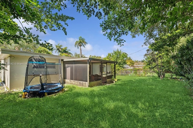 919 NE 4th St, Hallandale Beach, FL 33009 - view of green lawn with a trampoline and a sunroom