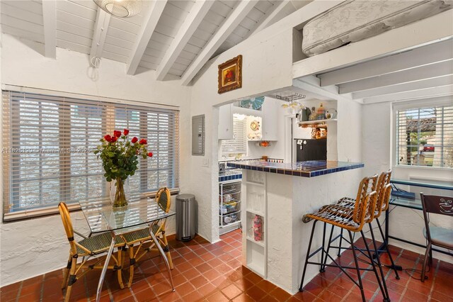 1301 Milan Ave Unit 1, Coral Gables, FL 33134 - kitchen featuring tile counters, a kitchen bar, open shelves, refrigerator, and wood ceiling