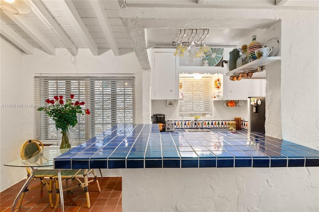 1301 Milan Ave Unit 1, Coral Gables, FL 33134 - kitchen featuring tile countertops, beam ceiling, white cabinets, a textured wall, and tile patterned floors