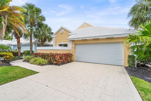 9047 Baybury Ln, West Palm Beach, FL 33411 - view of front of house featuring driveway, stucco siding, and a garage