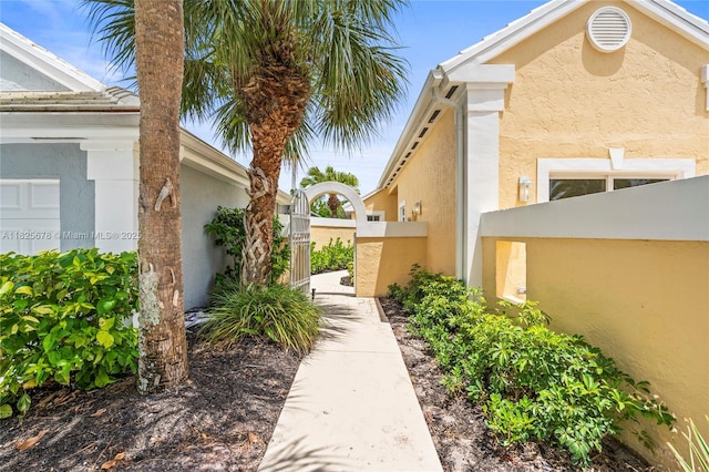 9047 Baybury Ln, West Palm Beach, FL 33411 - view of side of property with stucco siding and a gate