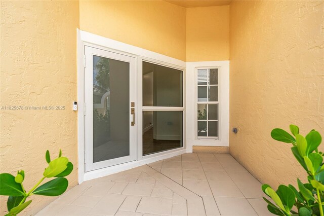 9047 Baybury Ln, West Palm Beach, FL 33411 - view of exterior entry featuring stucco siding and a patio area