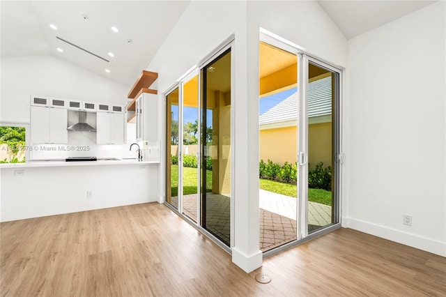 9047 Baybury Ln, West Palm Beach, FL 33411 - doorway with vaulted ceiling, light wood-style flooring, plenty of natural light, and recessed lighting
