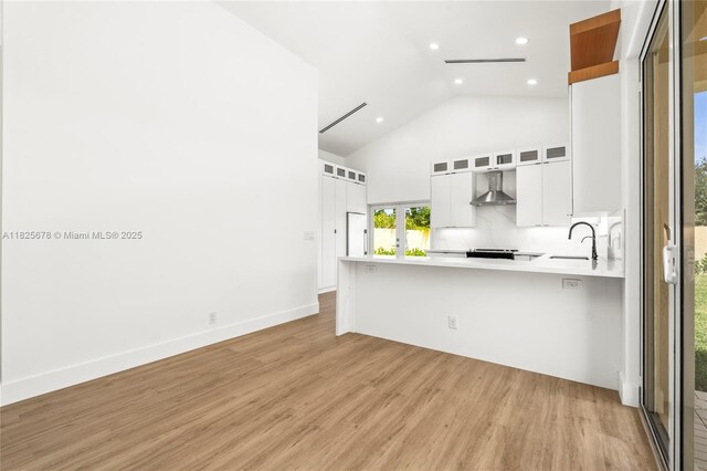 9047 Baybury Ln, West Palm Beach, FL 33411 - kitchen with wall chimney range hood, recessed lighting, light wood-type flooring, light countertops, and white cabinetry