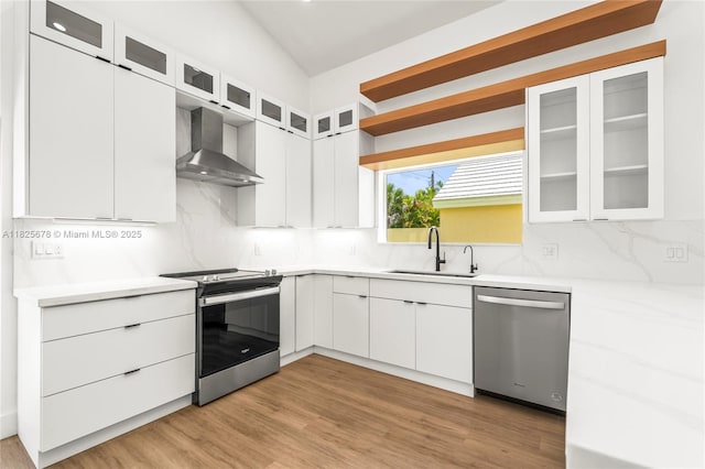 9047 Baybury Ln, West Palm Beach, FL 33411 - kitchen with appliances with stainless steel finishes, wall chimney range hood, decorative backsplash, light countertops, and white cabinets