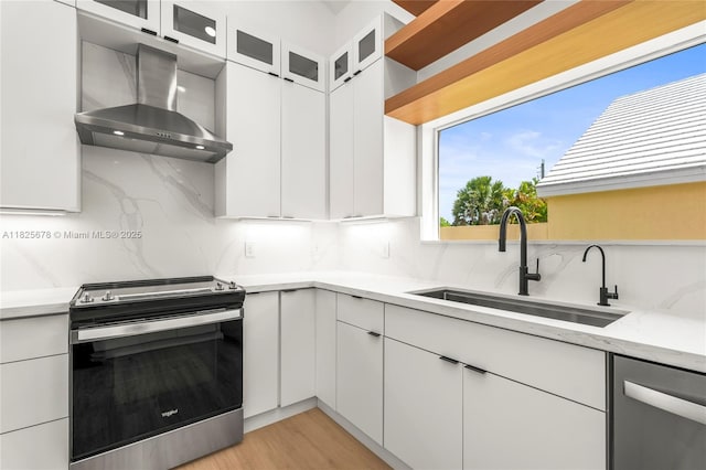 9047 Baybury Ln, West Palm Beach, FL 33411 - kitchen featuring stainless steel appliances, wall chimney exhaust hood, decorative backsplash, and white cabinetry