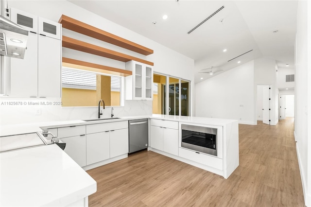 9047 Baybury Ln, West Palm Beach, FL 33411 - kitchen with appliances with stainless steel finishes, a peninsula, light wood-style floors, lofted ceiling, and light countertops