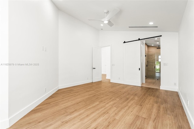 9047 Baybury Ln, West Palm Beach, FL 33411 - unfurnished bedroom featuring lofted ceiling, a barn door, recessed lighting, light wood-style floors, and ceiling fan