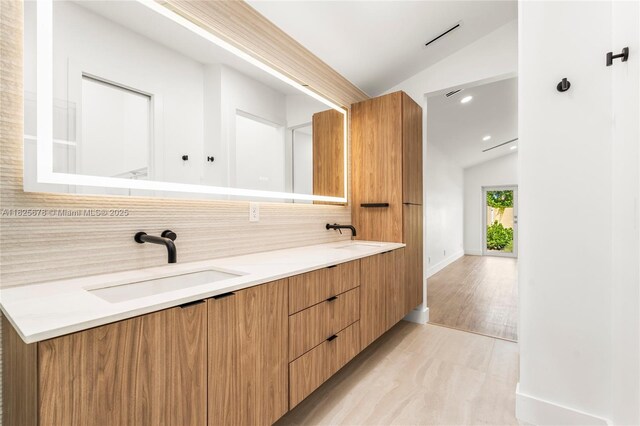 9047 Baybury Ln, West Palm Beach, FL 33411 - full bathroom with lofted ceiling, double vanity, wood finished floors, decorative backsplash, and recessed lighting