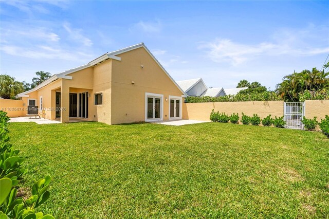 9047 Baybury Ln, West Palm Beach, FL 33411 - back of property with stucco siding and a patio area