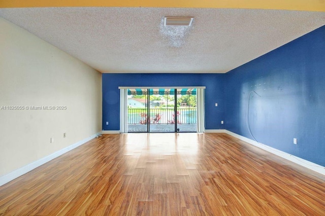 14716 Breckness Pl, Miami Lakes, FL 33016 - empty room featuring a textured ceiling and light wood-type flooring
