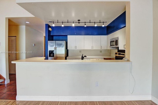 14716 Breckness Pl, Miami Lakes, FL 33016 - kitchen with stainless steel appliances, rail lighting, light countertops, white cabinetry, and a peninsula