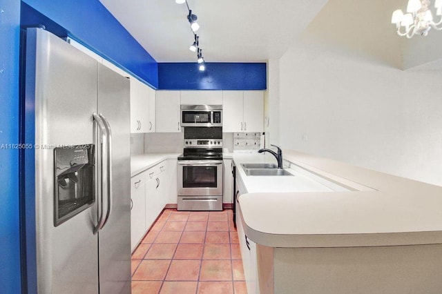 14716 Breckness Pl, Miami Lakes, FL 33016 - kitchen featuring appliances with stainless steel finishes, track lighting, a peninsula, light tile patterned floors, and light countertops