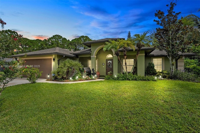 1025 SW Placetas Ave, Port St Lucie, FL 34953 - view of front of home featuring stucco siding, a lawn, a garage, and concrete driveway