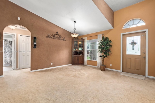 1025 SW Placetas Ave, Port St Lucie, FL 34953 - entryway with plenty of natural light, arched walkways, high vaulted ceiling, and carpet flooring