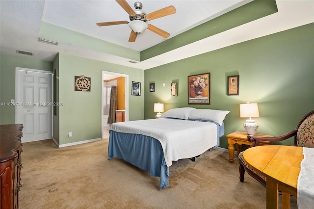 1025 SW Placetas Ave, Port St Lucie, FL 34953 - carpeted bedroom with a raised ceiling, connected bathroom, and ceiling fan