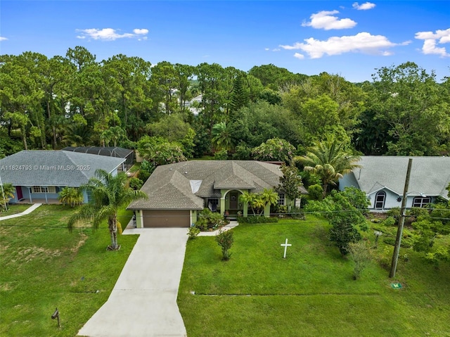 1025 SW Placetas Ave, Port St Lucie, FL 34953 - view of front of house featuring a garage, concrete driveway, a front lawn, and a lanai