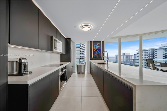 401 N Birch Rd Unit 1100, Fort Lauderdale, FL 33304 - kitchen featuring modern cabinets, appliances with stainless steel finishes, light countertops, light tile patterned floors, and dark cabinets