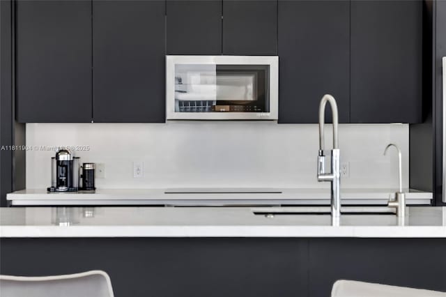 401 N Birch Rd Unit 1100, Fort Lauderdale, FL 33304 - kitchen featuring dark cabinetry, stainless steel microwave, light countertops, and modern cabinets