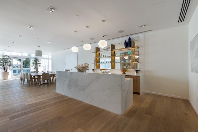 401 N Birch Rd Unit 1100, Fort Lauderdale, FL 33304 - kitchen with light wood finished floors, hanging light fixtures, light stone counters, a spacious island, and modern cabinets
