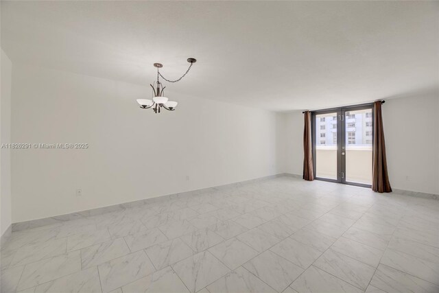 1621 Collins Ave Unit 708, Miami Beach, FL 33139 - empty room featuring a chandelier and baseboards