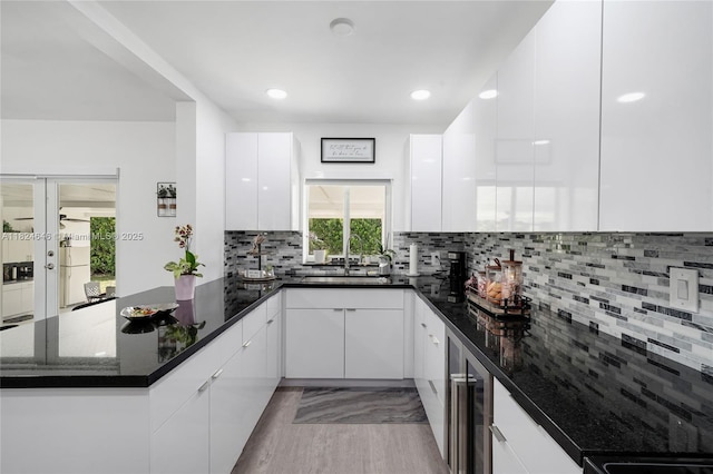 5290 Palm Ave, Hialeah, FL 33012 - kitchen with modern cabinets, a peninsula, white cabinets, wine cooler, and dark stone counters