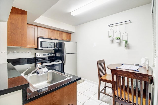 15549 N Miami Lakeway N Unit 104, Miami Lakes, FL 33014 - kitchen with appliances with stainless steel finishes, dark countertops, light tile patterned flooring, and brown cabinetry