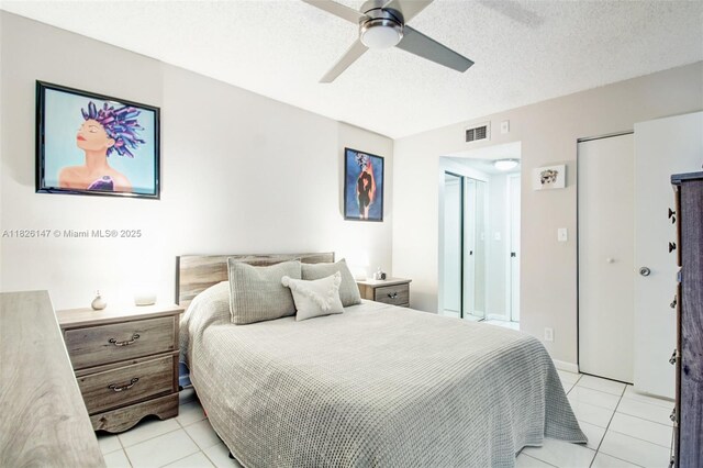 15549 N Miami Lakeway N Unit 104, Miami Lakes, FL 33014 - bedroom with light tile patterned floors, a textured ceiling, ceiling fan, and two closets