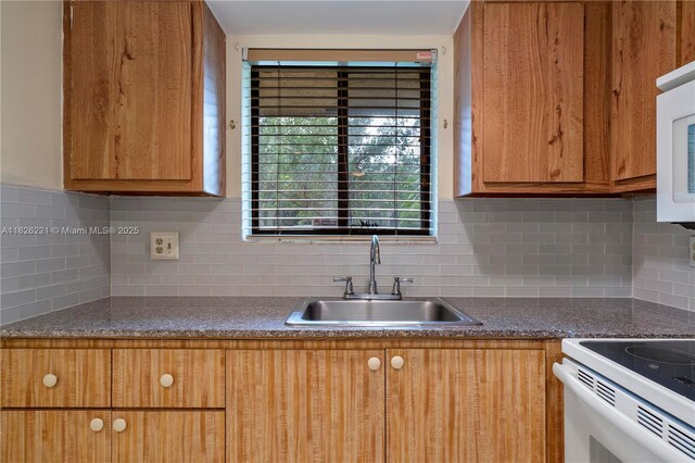 1125 S Flagler Ave Unit 511, Pompano Beach, FL 33060 - kitchen with backsplash, brown cabinetry, and dark countertops