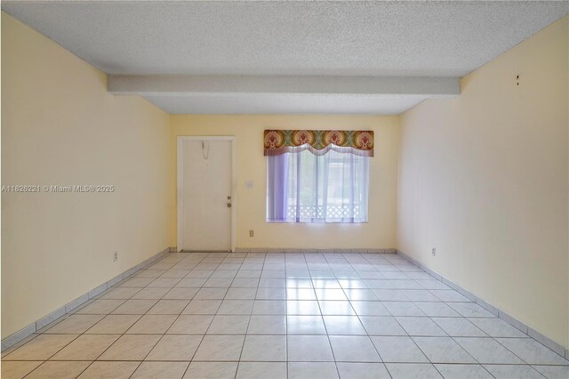 1125 S Flagler Ave Unit 511, Pompano Beach, FL 33060 - spare room with a textured ceiling, light tile patterned floors, and beam ceiling